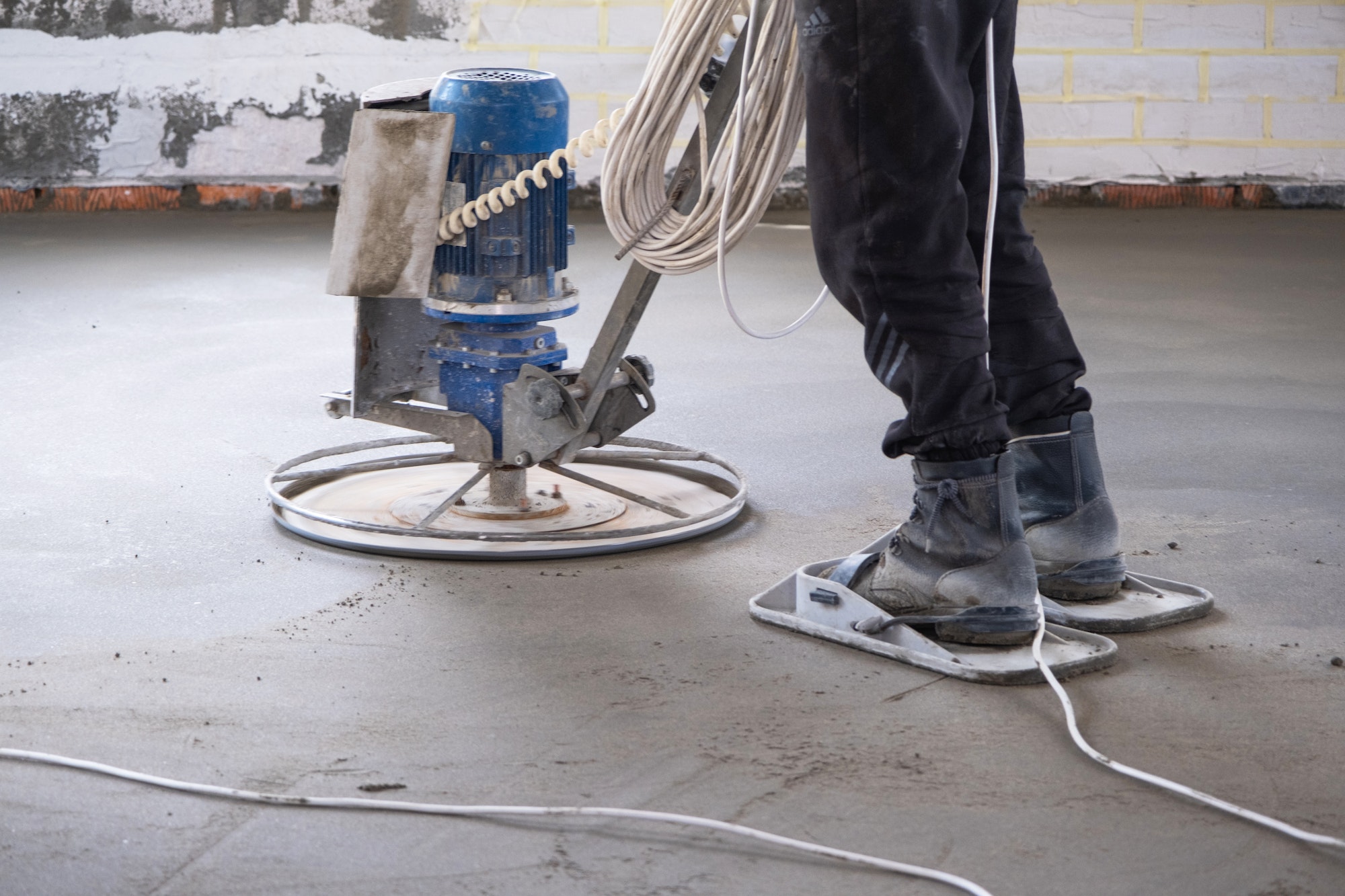 Ramming and grinding of semi-dry floor screed by a machine with a rotating disk for leveling